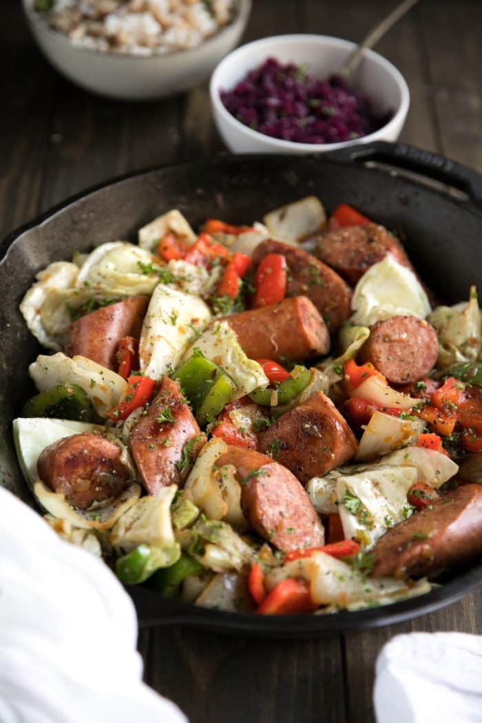 Large black cast iron skillet filled with cooked Kielbasa with Bell Peppers and Cabbage