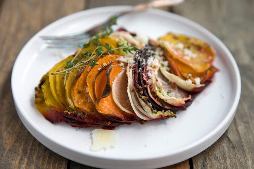 Scalloped Root Vegetable Skillet. Skillet baked with thinly sliced red and yellow beets, sweet potatoes, and parsnips topped with rosemary, butter and parmesan cheese.