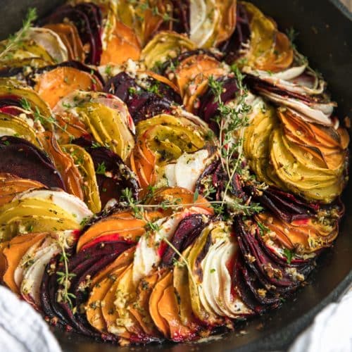 Scalloped Root Vegetable Skillet. Skillet baked with thinly sliced red and yellow beets, sweet potatoes, and parsnips topped with rosemary, butter and parmesan cheese.