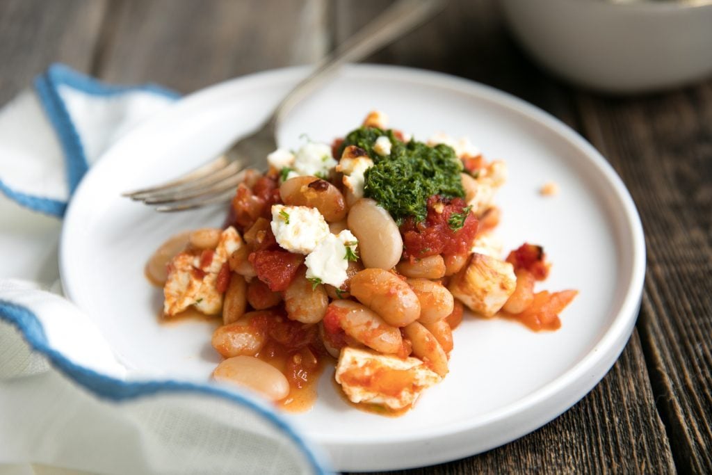 Fiber-filled white beans, sweet tomatoes, and tangy feta make this Tomato Baked Vegetarian Beans with Tangy Feta an easy and healthy anytime dinner loved by the whole family. Serve with homemade parsley pesto and fresh, crusty bread for an unforgettable Meatless Monday dish.