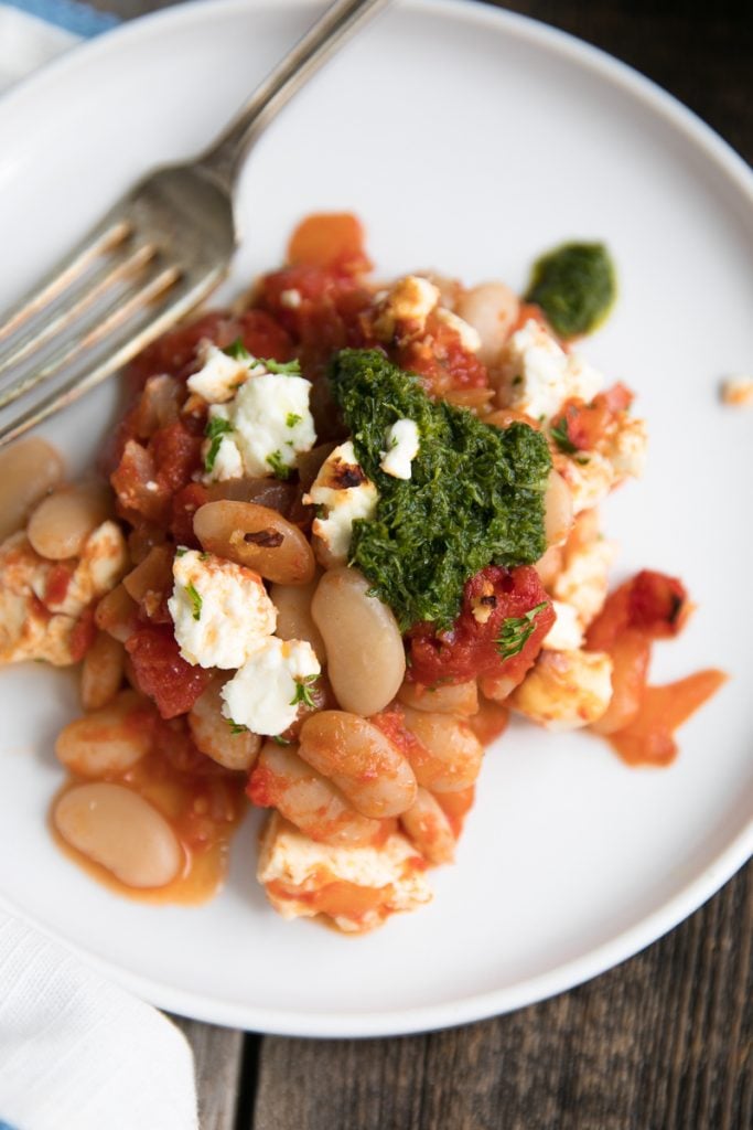 Fiber-filled white beans, sweet tomatoes, and tangy feta make this Tomato Baked Vegetarian Beans with Tangy Feta an easy and healthy anytime dinner loved by the whole family. Serve with homemade parsley pesto and fresh, crusty bread for an unforgettable Meatless Monday dish.