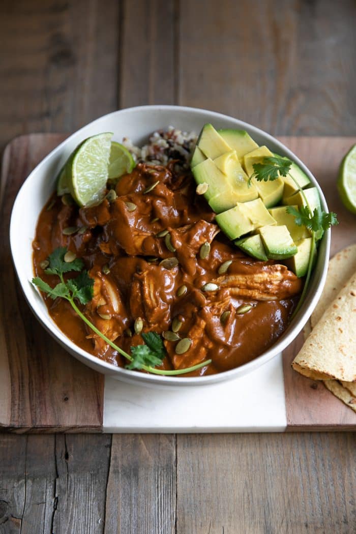 Mole sauce served with shredded chicken over rice with avocado and fresh lime.