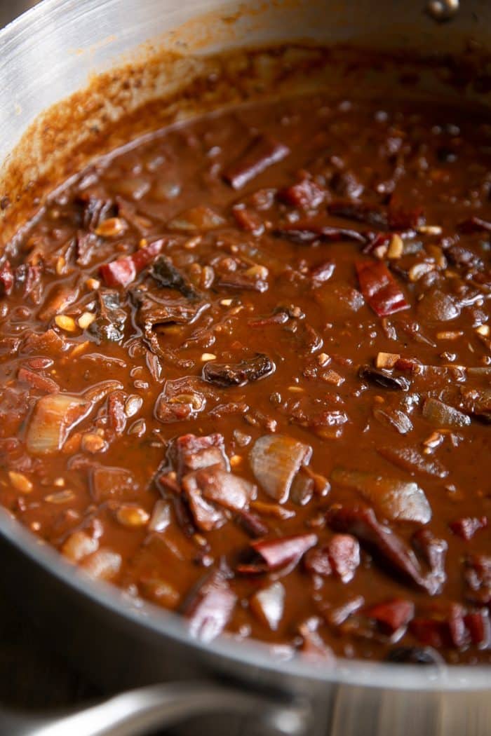 Homemade mole sauce cooking in a large pot before being blended into a smooth sauce.