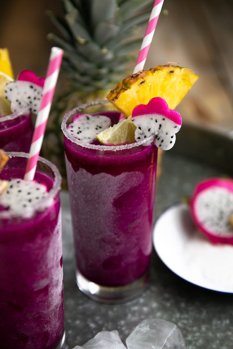 Frozen Pineapple Dragon Fruit Margaritas. Cold, crisp, and refreshing, these Frozen Pineapple Dragon Fruit Margaritas are the perfect solution for all those hot summer days and backyard BBQs. Swap the tequila for pineapple juice to make a healthy, fruit packed smoothie loved by both kids and adults! via @theforkedspoon #margarita #tequila #cocktail #frozenmargarita #drinkrecipe #dragonfruit | https://theforkedspoon.com/ easy iced dragon fruit margarita
