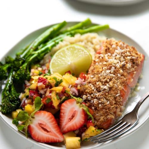 A plate of food with broccoli, with salmon crusted with Macadamia and Mango