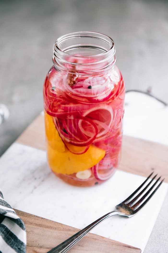 Red onions pickling in a homemade pickling mixture.