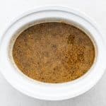 Fully cooked Crock Pot pork chile verde keeping warm in a large white slow cooker.