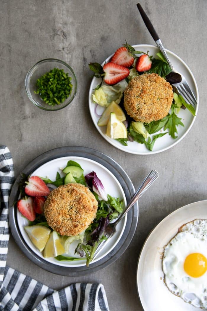 plated salmon crab cakes on a bed of lettuce and side of strawberries