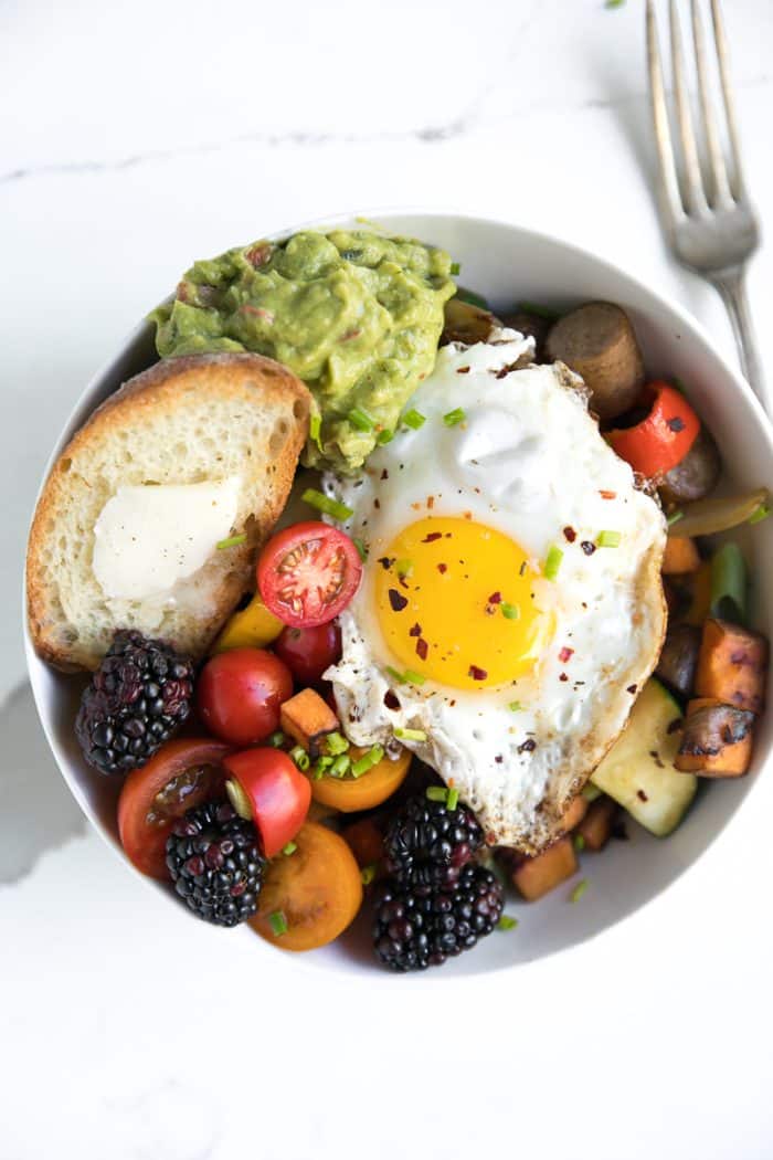 Sweet Pepper and Sausage Breakfast Hash with egg, guacamole, tomato, and sweet potato