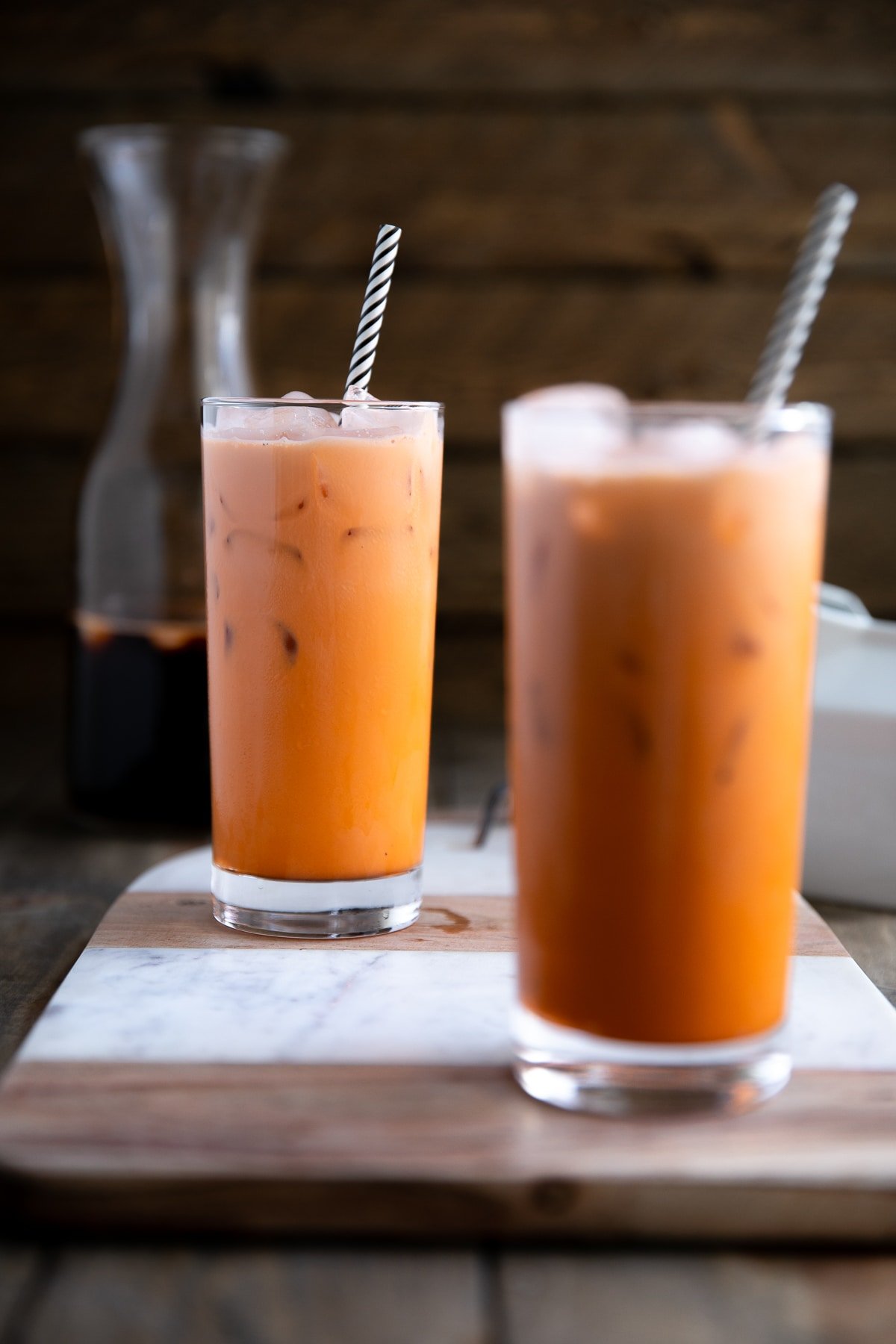 Two glasses filled with prepared and iced Thai iced tea.