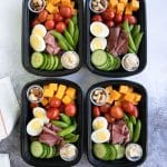 High protein snacks including cheese, egg, deli meat, hummus, and nuts in meal prep containers
