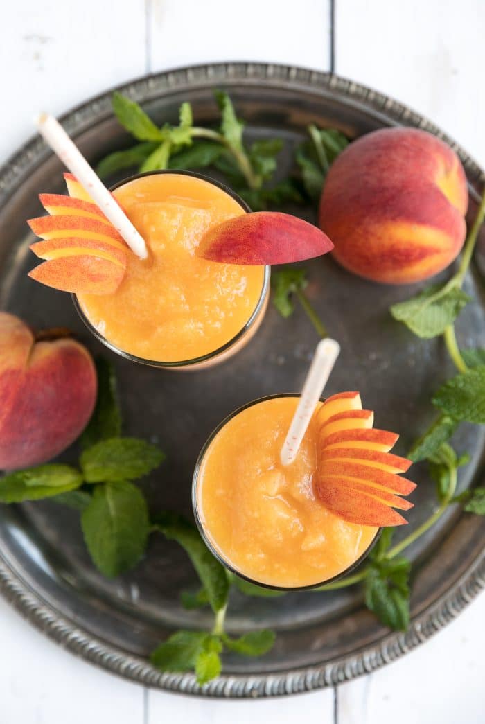 Overhead image of two glasses filled with frozen peach and wine slushie