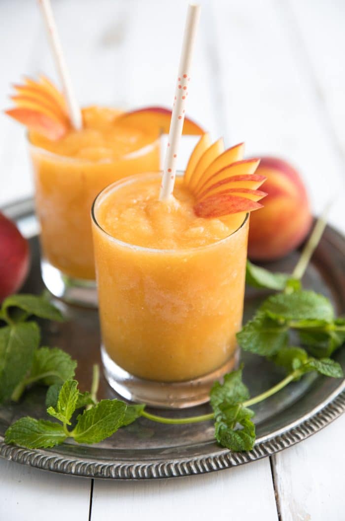 Wine slushies made with frozen peaches and white wine served in high ball glasses.