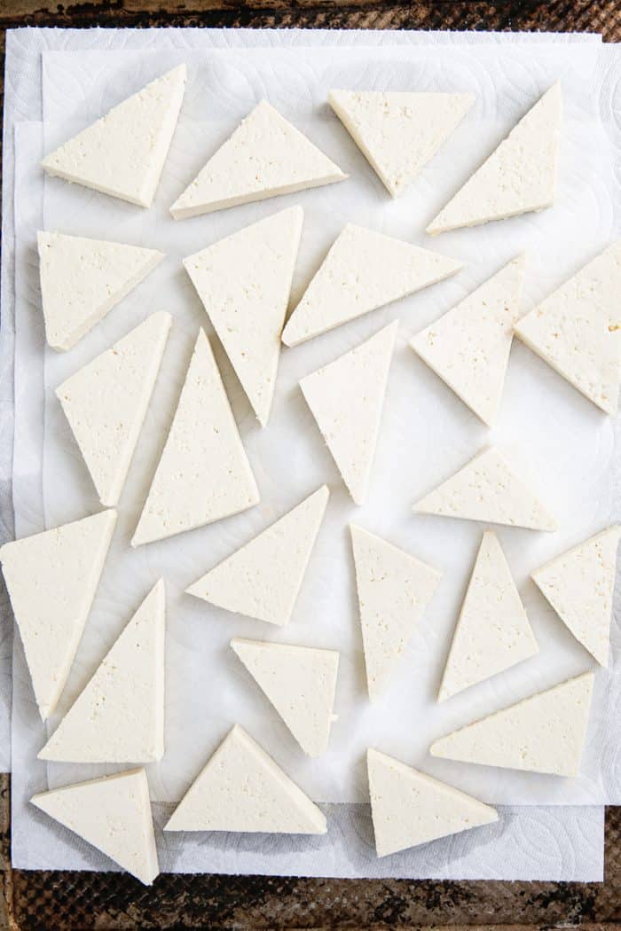 firm tofu cut into triangles on a paper towel