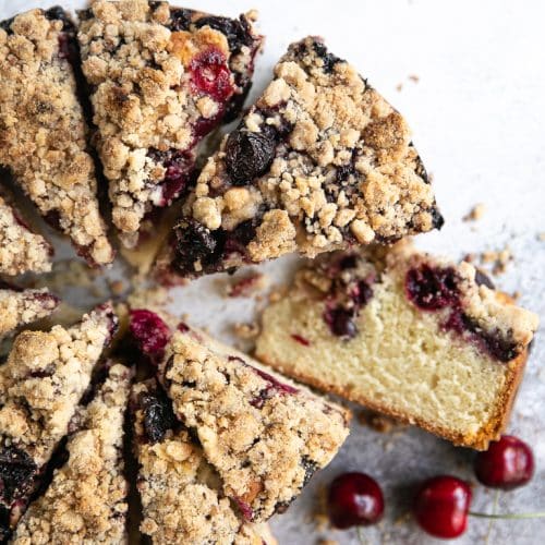 A piece of cherry coffee cake on a plate, with Cherry