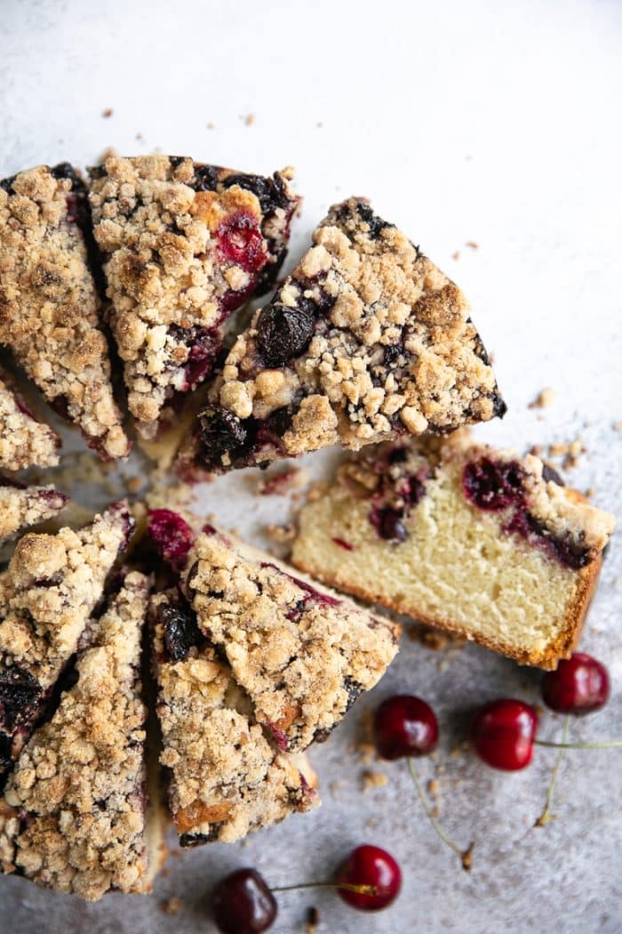 overhead shot of a sliced cherry cake with crumb topping