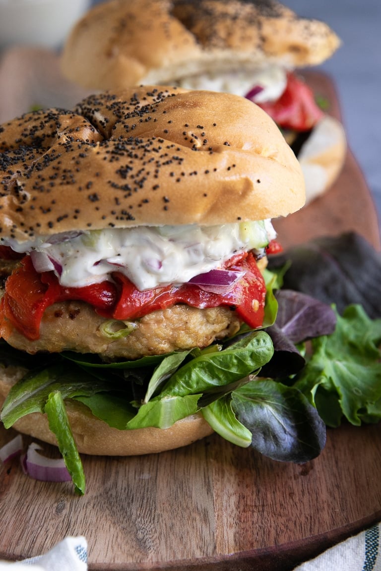 Prepared Grilled Turkey Burgers with fresh greens, roasted red peppers, and cucumber yogurt topping