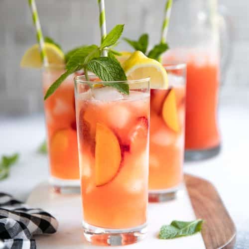 A close up of glasses filled with Peach strawberry Lemonade