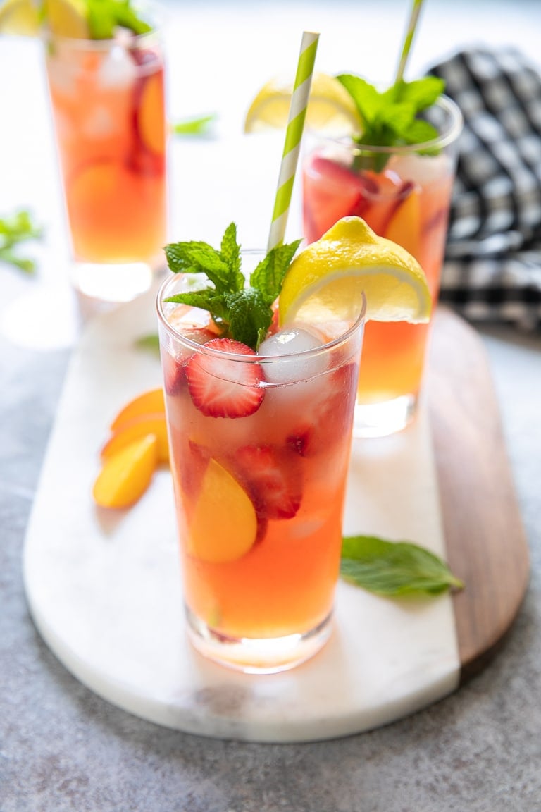 Bright pink strawberry and peach lemonade filled with fresh peaches and strawberries