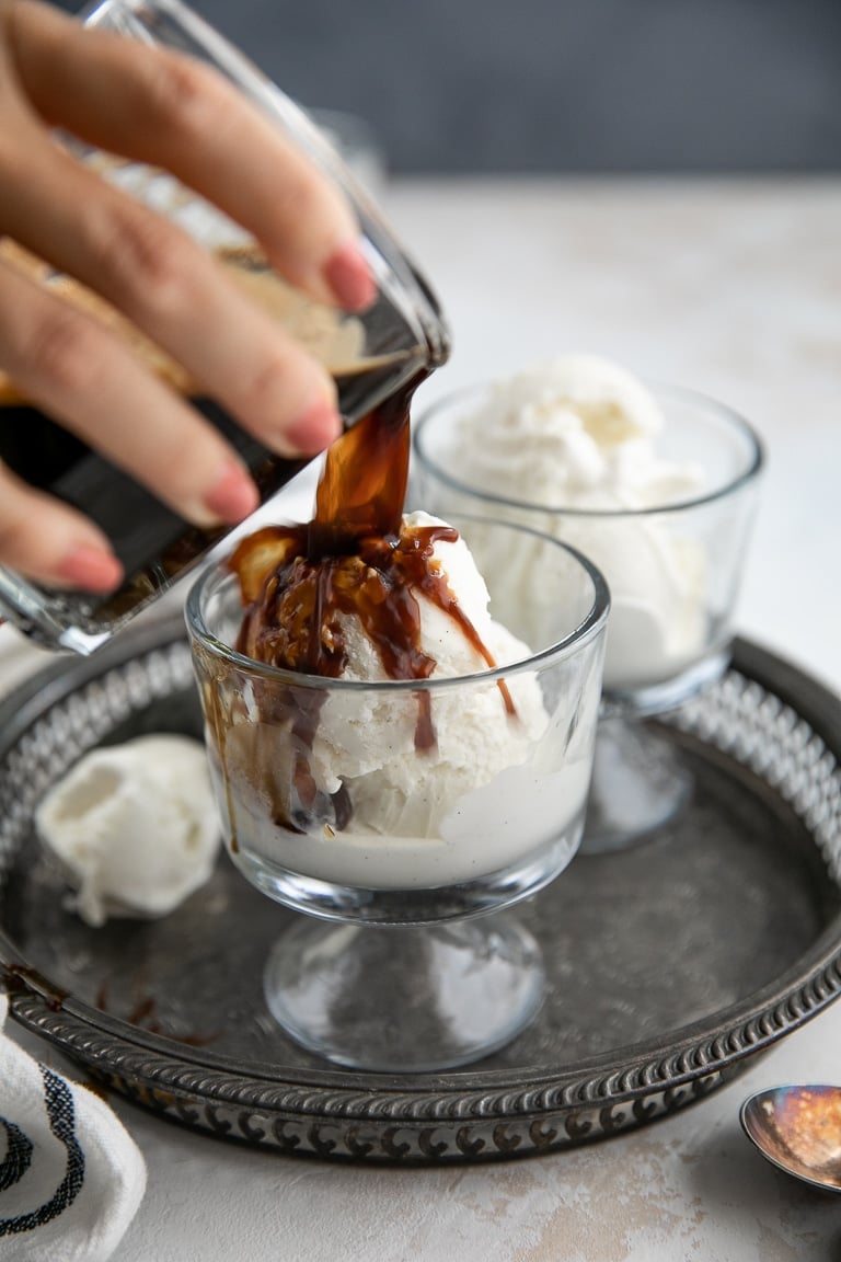 Espresso being poured over ice cream to make an Affogato