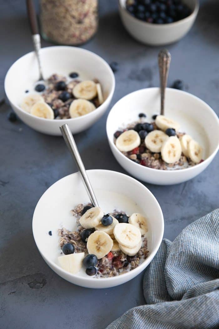 Three bowls of homemade berry oatmeal with banana and blueberries