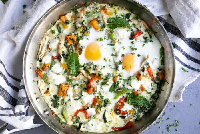 Healthy egg white frittata in a large skillet garnished with fresh herbs