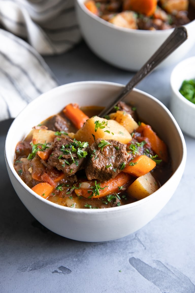 White bowls filled with juicy chunks of beef stew