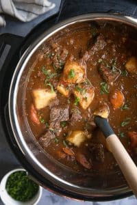 Instant Pot filled with cooked beef stew filled with beef chunks, potatoes, and carrots.