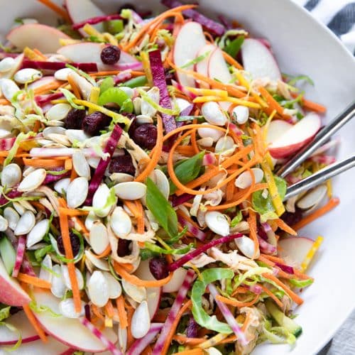 A bowl of shredded brussels sprouts salad with chicken and beets