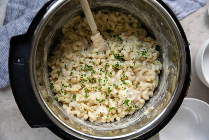 Cooked mac and cheese garnished with fresh parsley in a large instant pot.