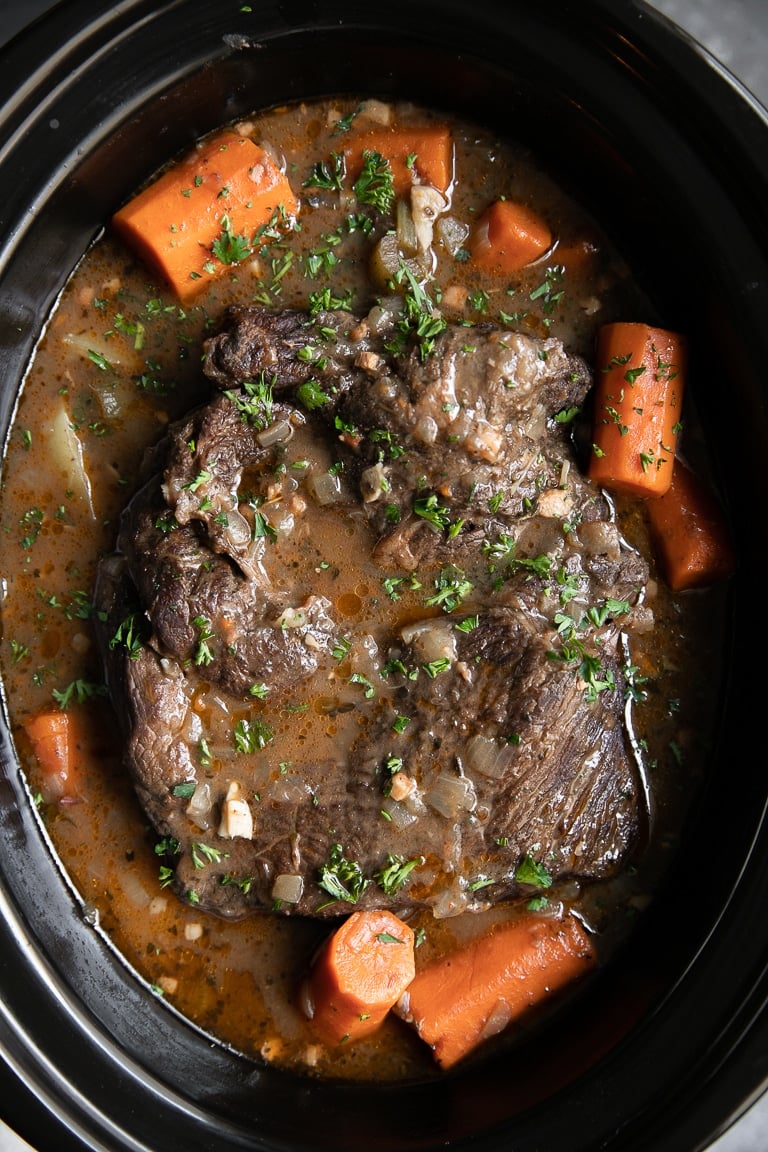 A slow cooker filled with meat and vegetables