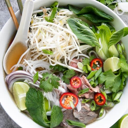 A bowl of Vietnamese Pho with a spoonful of bone broth