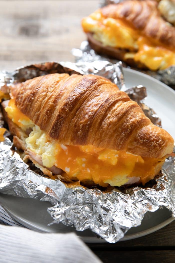 Large butter croissant filled with egg, ham, and melted cheddar cheese.