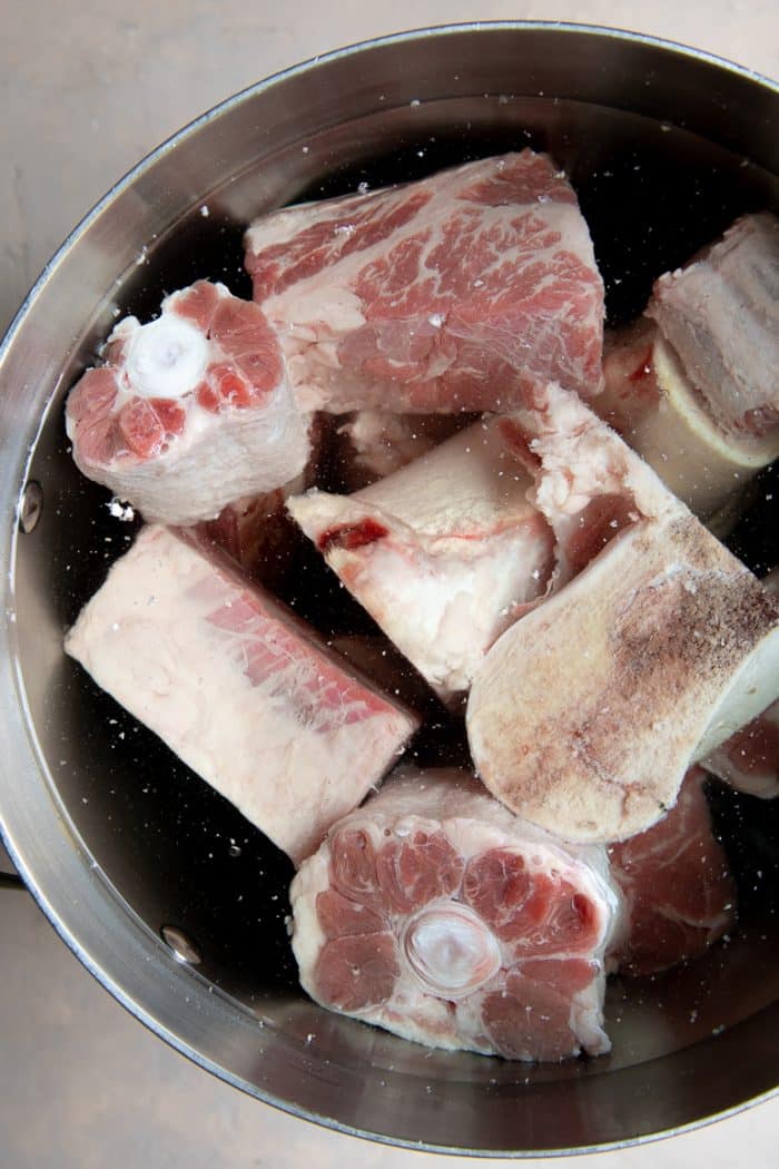 Large stockpot filled with beef bones and filled with cold water.