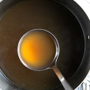 Perfect, clear, beef bone broth in a large stockpot.