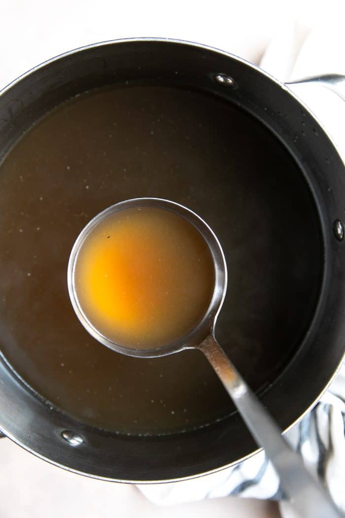 Perfect, clear, beef bone broth in a large stockpot.