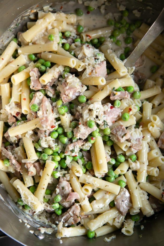 Large pot filled with cooked Ziti, a light parmesan cream sauce, peas, and leftover holiday ham.