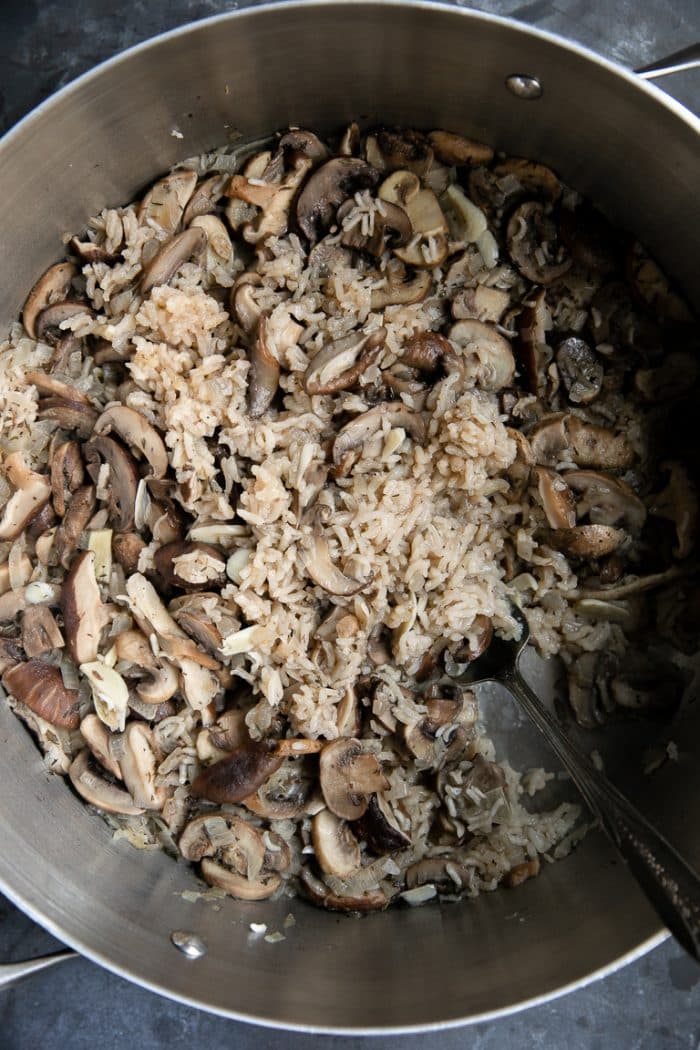 Fully cooked mushroom rice pilaf in a large steel pot.