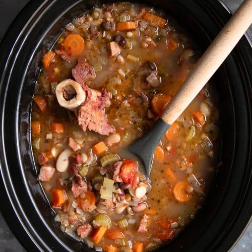 A slow cooker filled with Ham and Bean soup