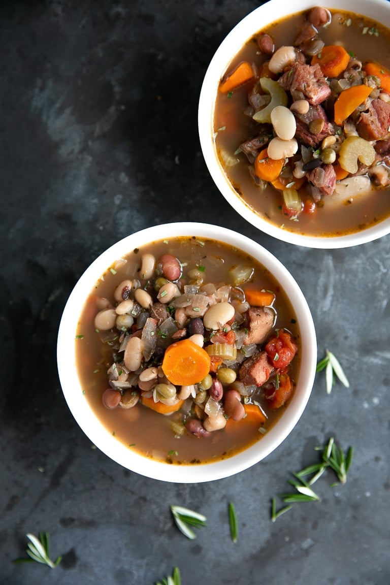 Two white bowls filled with ham and bean soup.