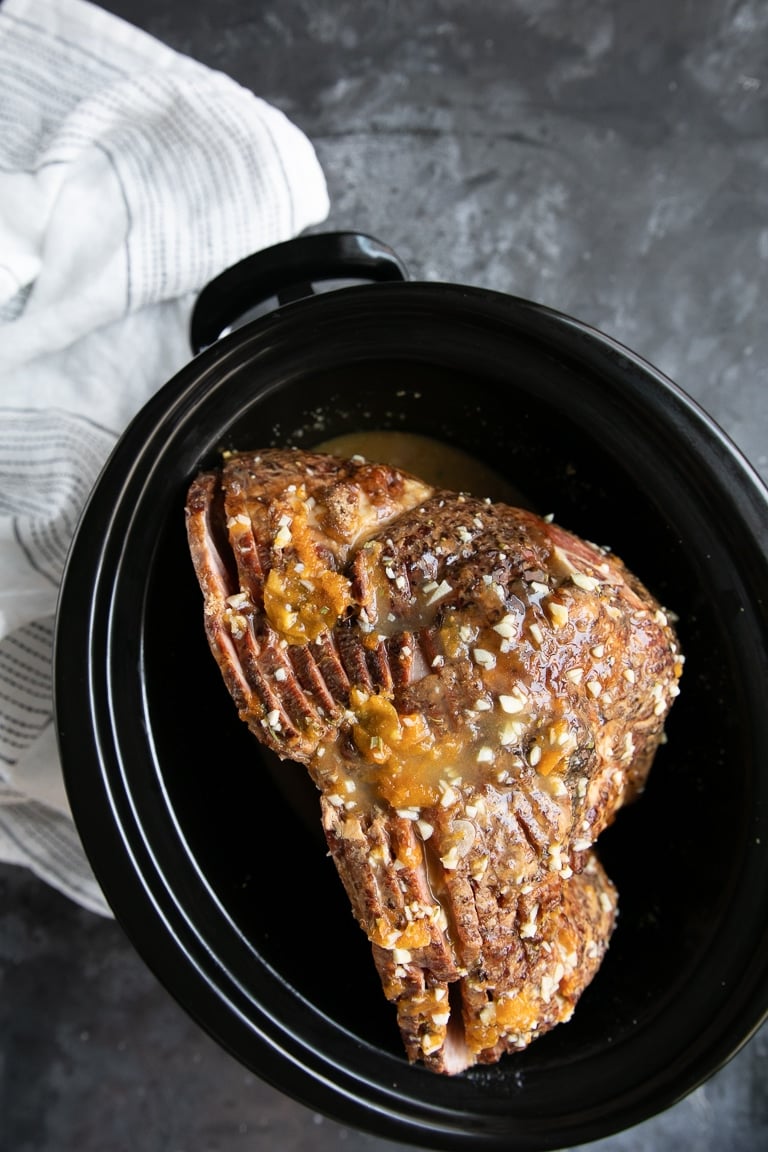 Slow cooker Ham covered in marmalade glaze and ready to be cooked.
