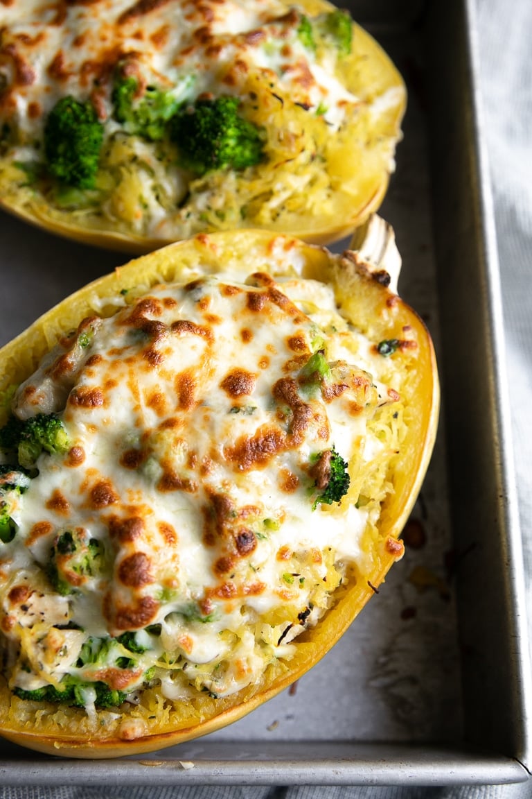 Half of a baked spaghetti squash filled with chicken, broccoli, and cheese.