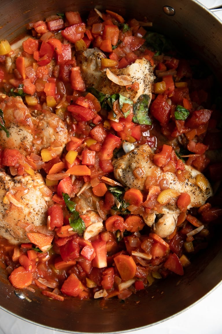 A bowl filled with meat and vegetables, with Cacciatore Chicken