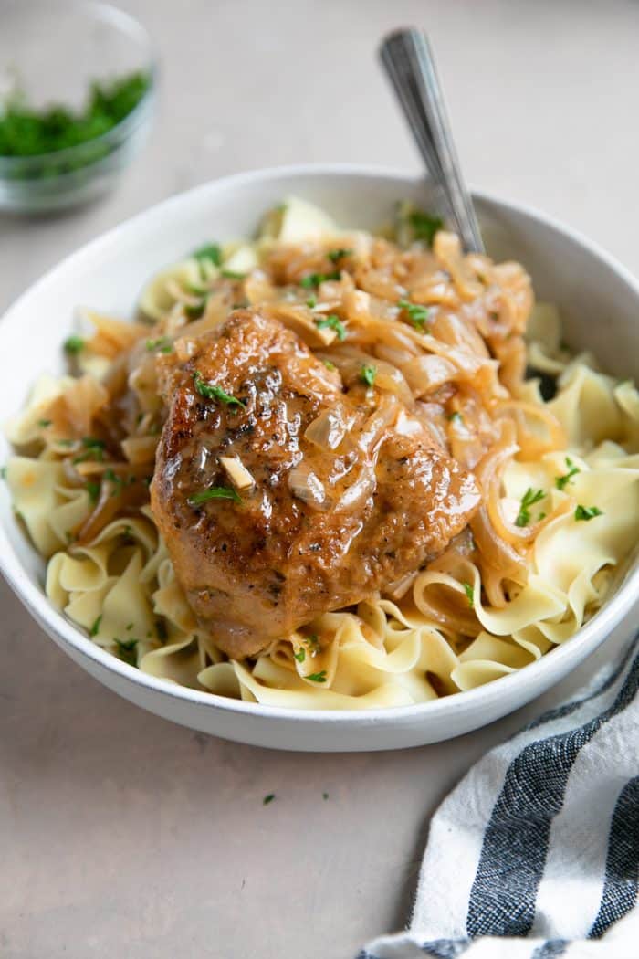 Single serving of chicken paprikash with chicken thigh, cooked onions, sauce, and egg noodles.