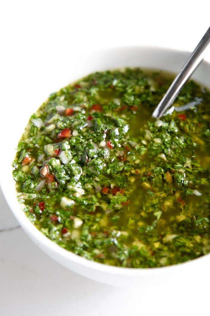 White bowl filled with authentic green chimichurri sauce.