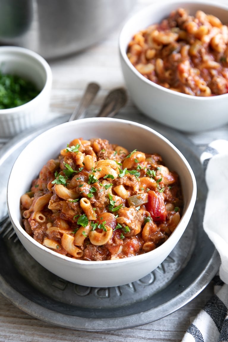 White bowl filled with American Goulash made with ground beef, tomatoes, and elbow macaroni.