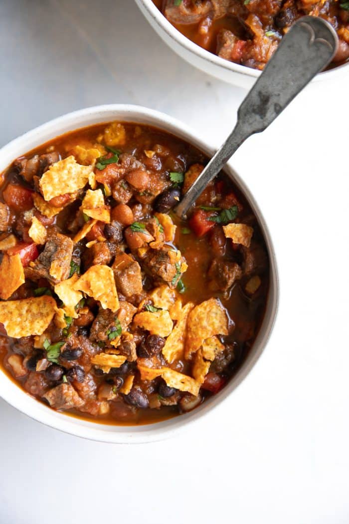 Overhead image of white bowl filled steak chili.