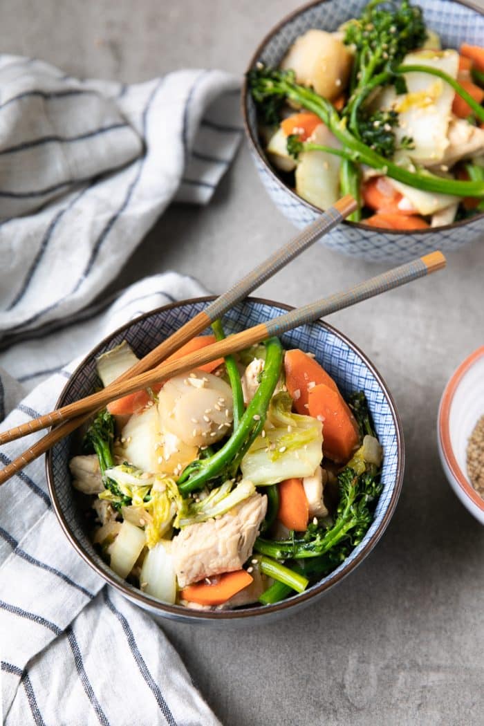 Two blue and white patterned bowls filled with chicken cabbage stir fry.