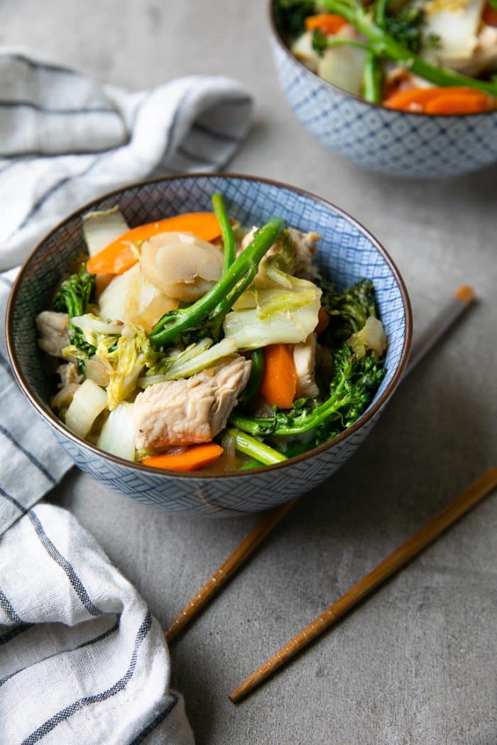 Fully prepared chicken and cabbage stir fry with broccoli, carrots, and water chestnuts in a light garlic ginger sauce.