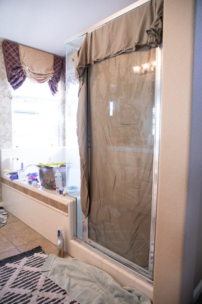 Soaking a glass shower door in white vinegar.